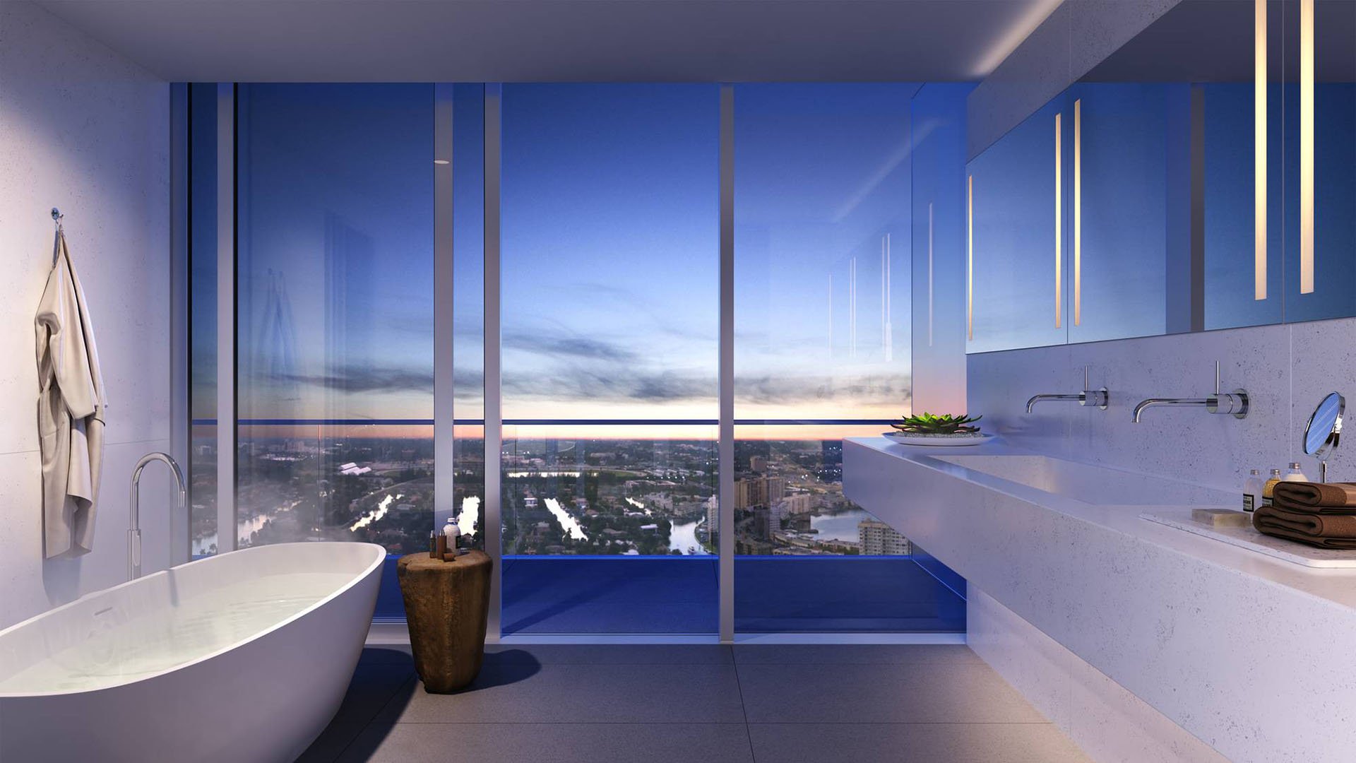 2000 Ocean Hallandale Beach spa bathroom with freestanding tub, double vanity and floor-to-ceiling sunset views, showcasing luxury and ultra luxury resale condos interiors on the South Florida coast.