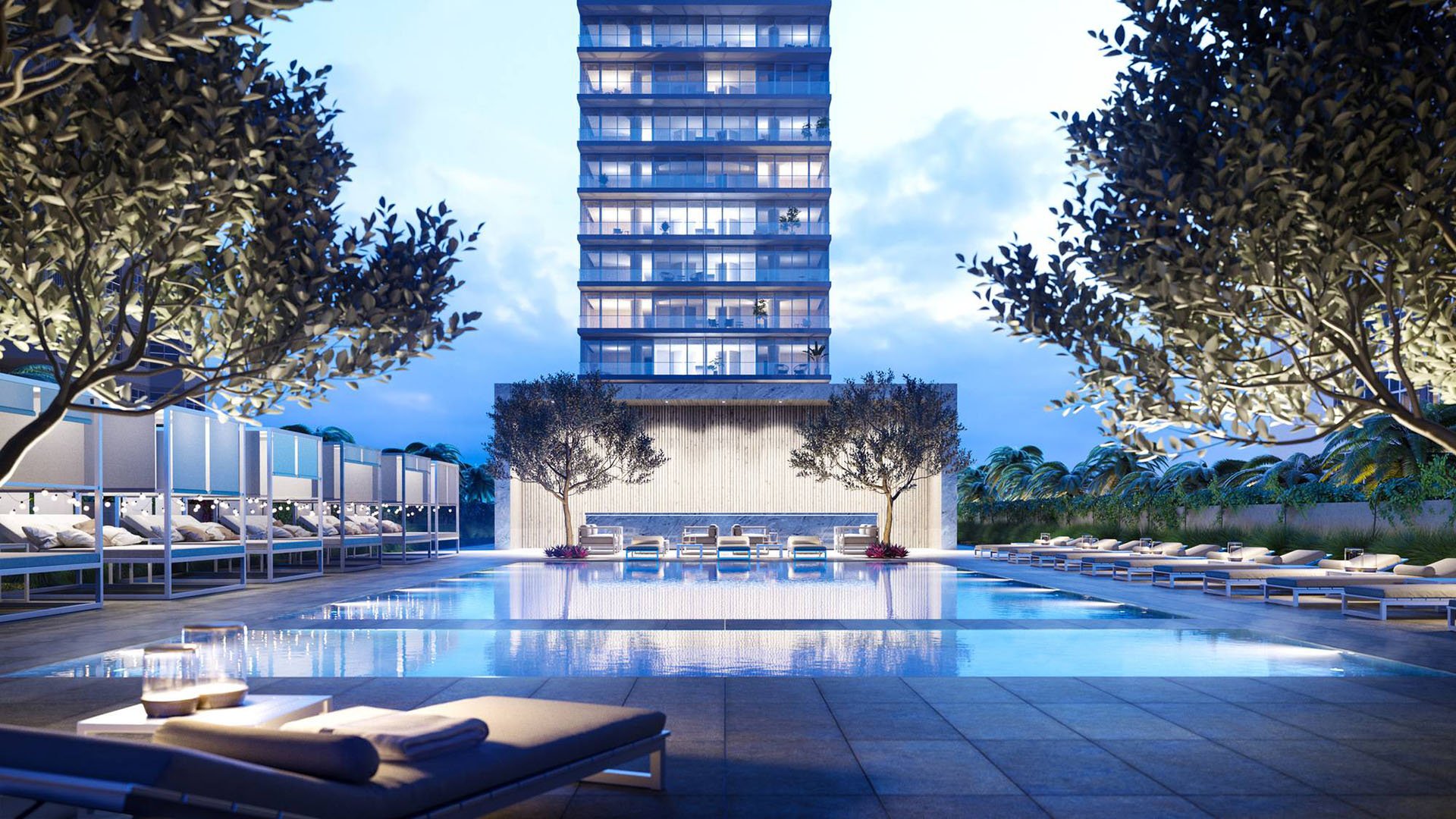 Evening pool at 2000 Ocean Hallandale Beach with cabanas, loungers and illuminated tower backdrop, showcasing luxury and ultra luxury resale condos amenities in South Florida.