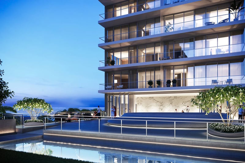 2000 Ocean in Hallandale Beach, Florida, oceanfront terrace at dusk with glass balconies, landscaped planters and reflecting pool, highlighting luxury and ultra luxury preconstruction condos.