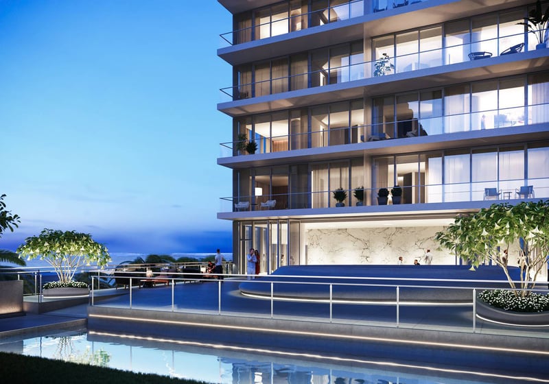 2000 Ocean in Hallandale Beach, Florida, oceanfront terrace at dusk with glass balconies, landscaped planters and reflecting pool, highlighting luxury and ultra luxury preconstruction condos.