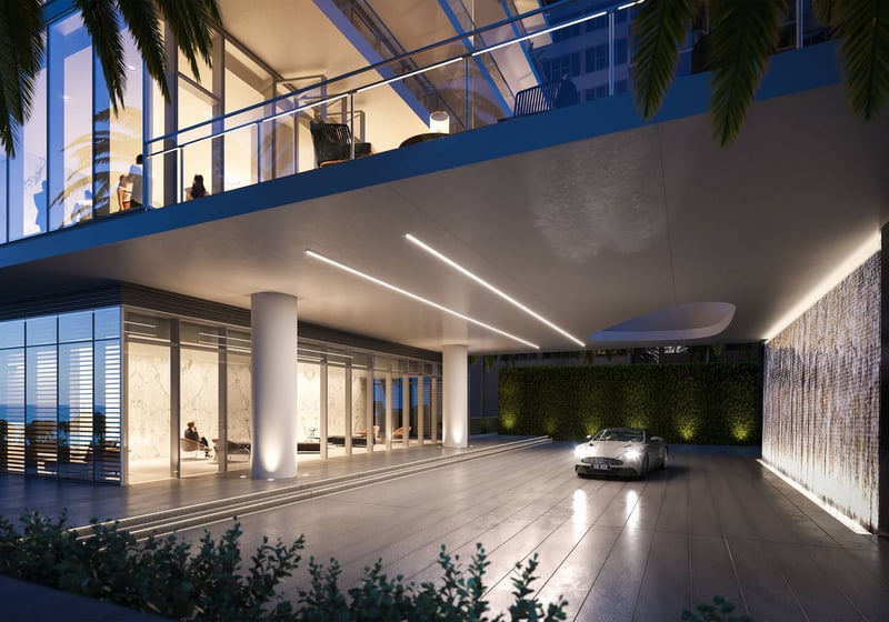 2000 Ocean, Hallandale Beach, Florida, porte-cochere arrival at night with waterfall wall, palms and bright lobby, promoting luxury and ultra luxury preconstruction condos.