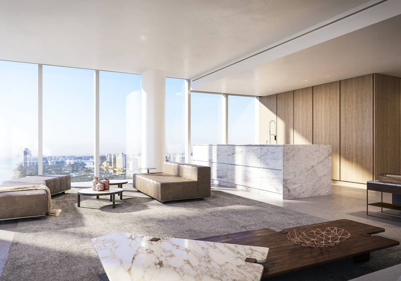 Sunlit interior at 2000 Ocean, Hallandale Beach, Florida, with marble kitchen island, open living area and panoramic skyline views, highlighting luxury and ultra luxury preconstruction condos.