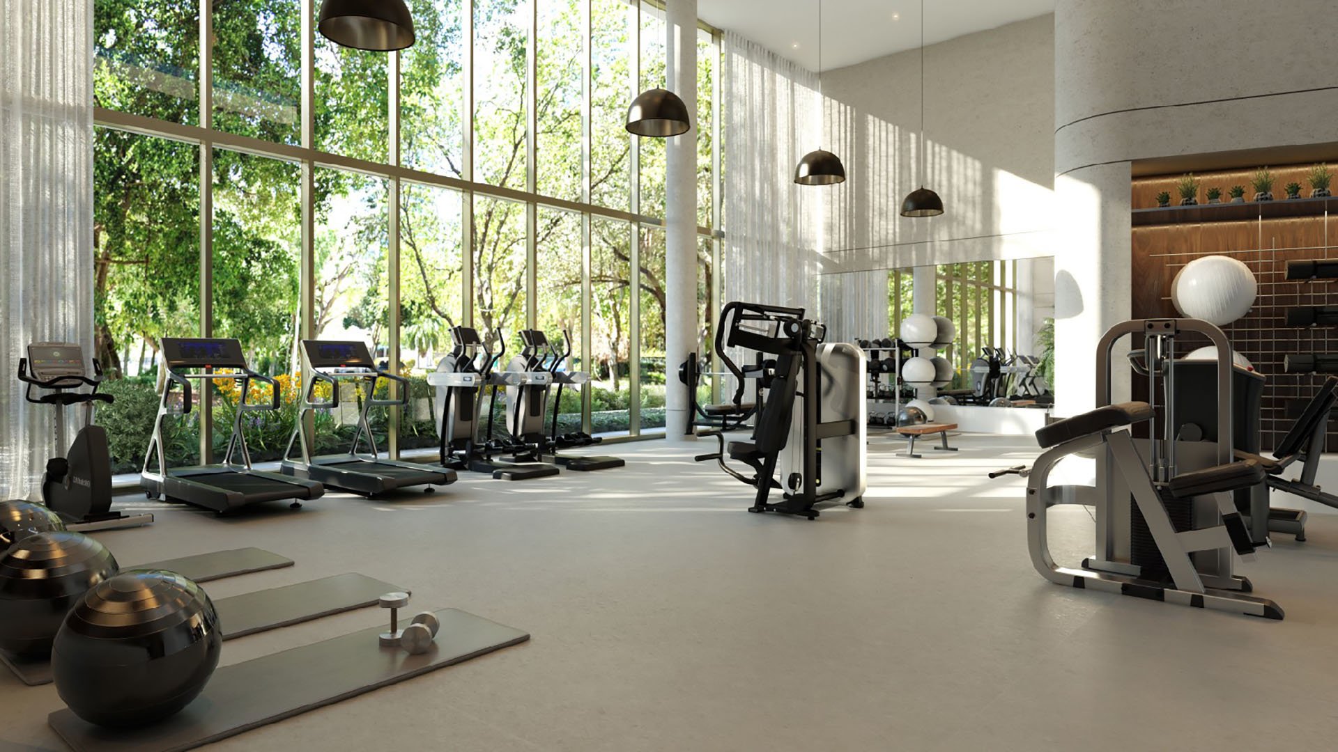 2200 Brickell fitness center with floor-to-ceiling windows, treadmills, strength equipment and yoga mats, showcasing luxury and ultra luxury preconstruction condos amenities in Brickell, Miami, Florida.