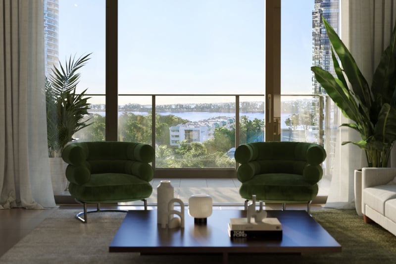 2200 Brickell, Brickell Miami, Florida living room with green lounge chairs facing balcony and Biscayne Bay views, showcasing luxury and ultra luxury preconstruction condos with panoramic water and skyline scenery.