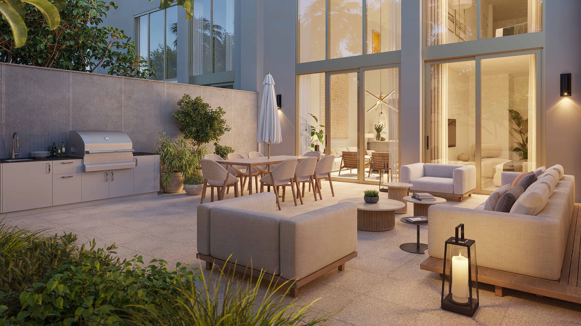 2200 Brickell, Brickell Miami, Florida private patio with outdoor kitchen grill, dining table and lounge seating at dusk beside double-height glass, highlighting luxury and ultra luxury preconstruction condos with resort-style entertaining space.