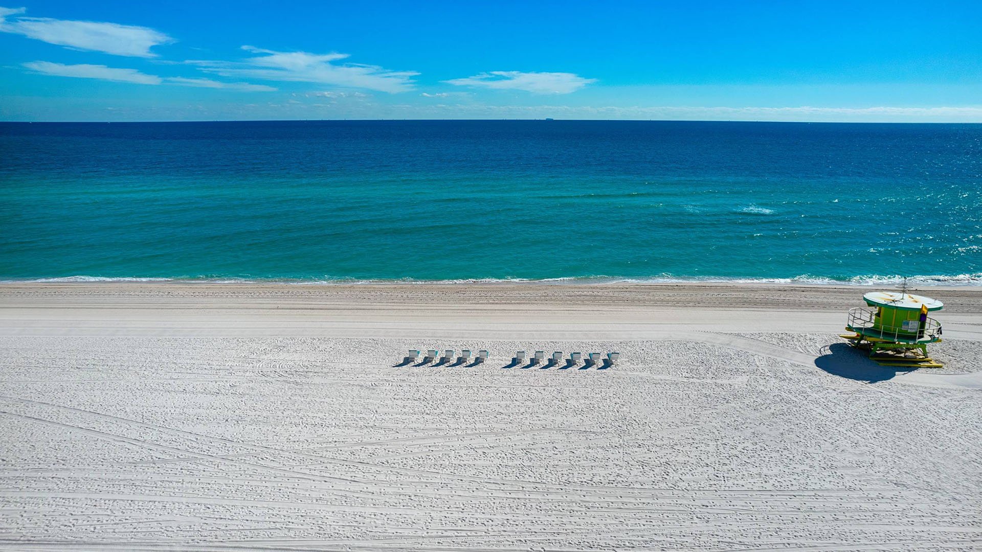57 Ocean Miami Beach lifeguard tower and sunbeds on Atlantic beachfront, showcasing luxury and ultra luxury preconstruction condos on Millionaire's Row, Mid-Beach, Miami Beach, Florida.