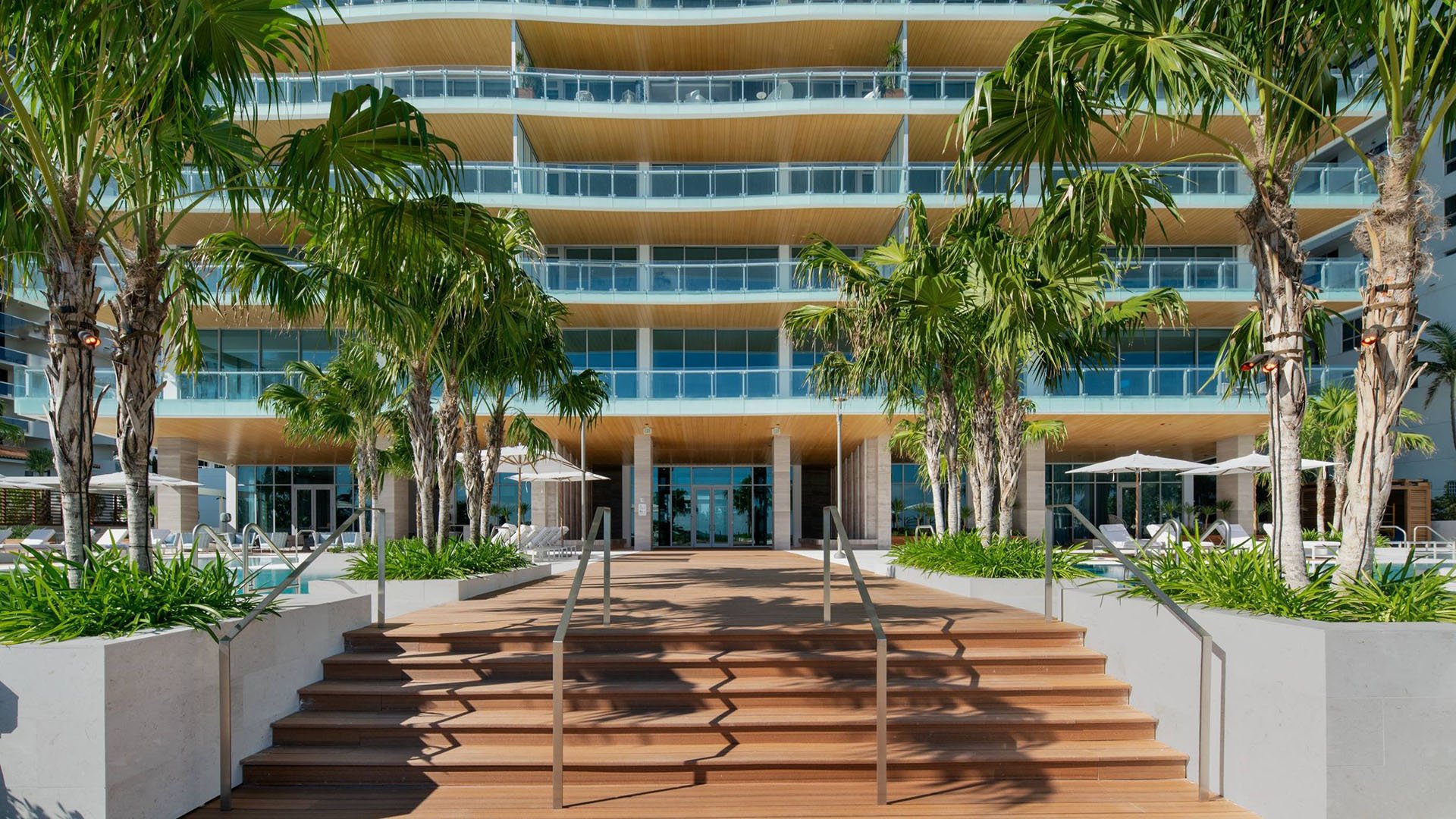 57 Ocean Miami Beach hotel-style entrance with poolside view and modern facade, showcasing luxury and ultra luxury preconstruction condos on Millionaire's Row, Mid-Beach, Miami Beach, Florida.