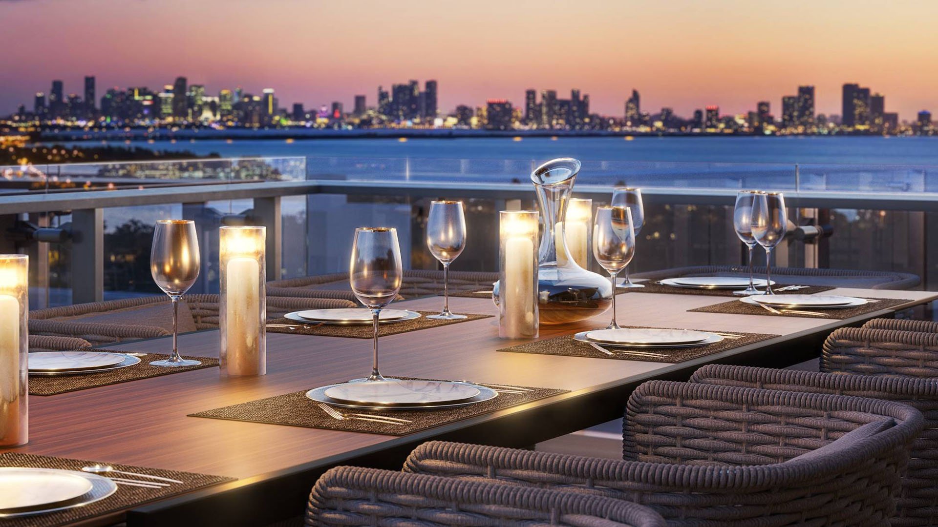 57 Ocean Miami Beach rooftop dinner setup with city view at sunset, showcasing luxury and ultra luxury preconstruction condos entertaining in Mid-Beach, Miami Beach, Florida.