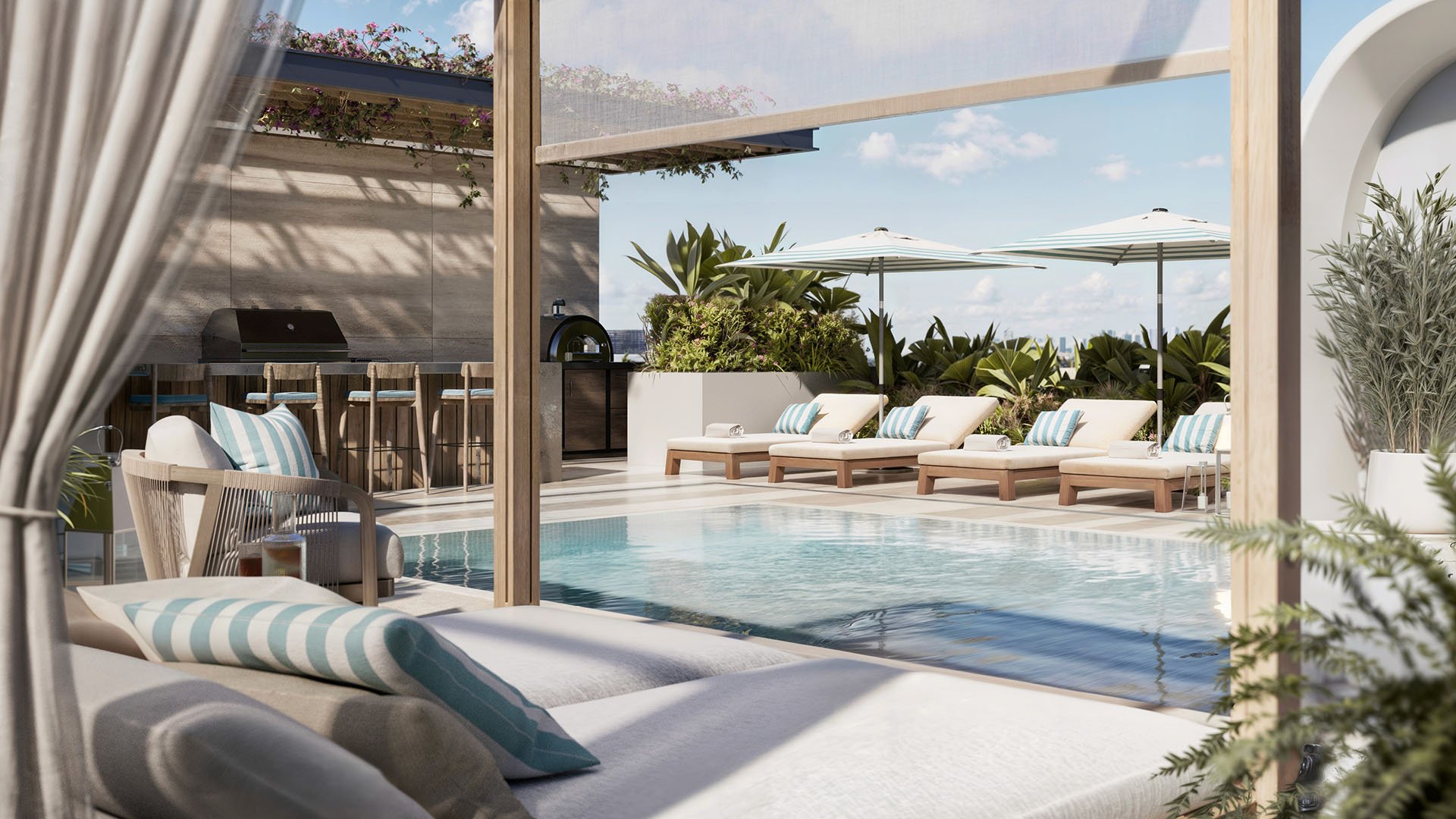 Rooftop pool terrace at Alma Bay Harbor in Bay Harbor Islands, Miami, highlighting amenities for luxury and ultra luxury preconstruction condos with sun loungers, outdoor kitchen and tropical landscaping.