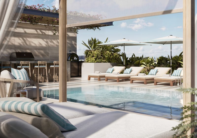 Rooftop pool terrace at Alma Bay Harbor in Bay Harbor Islands, Miami, highlighting amenities for luxury and ultra luxury preconstruction condos with sun loungers, outdoor kitchen and tropical landscaping.