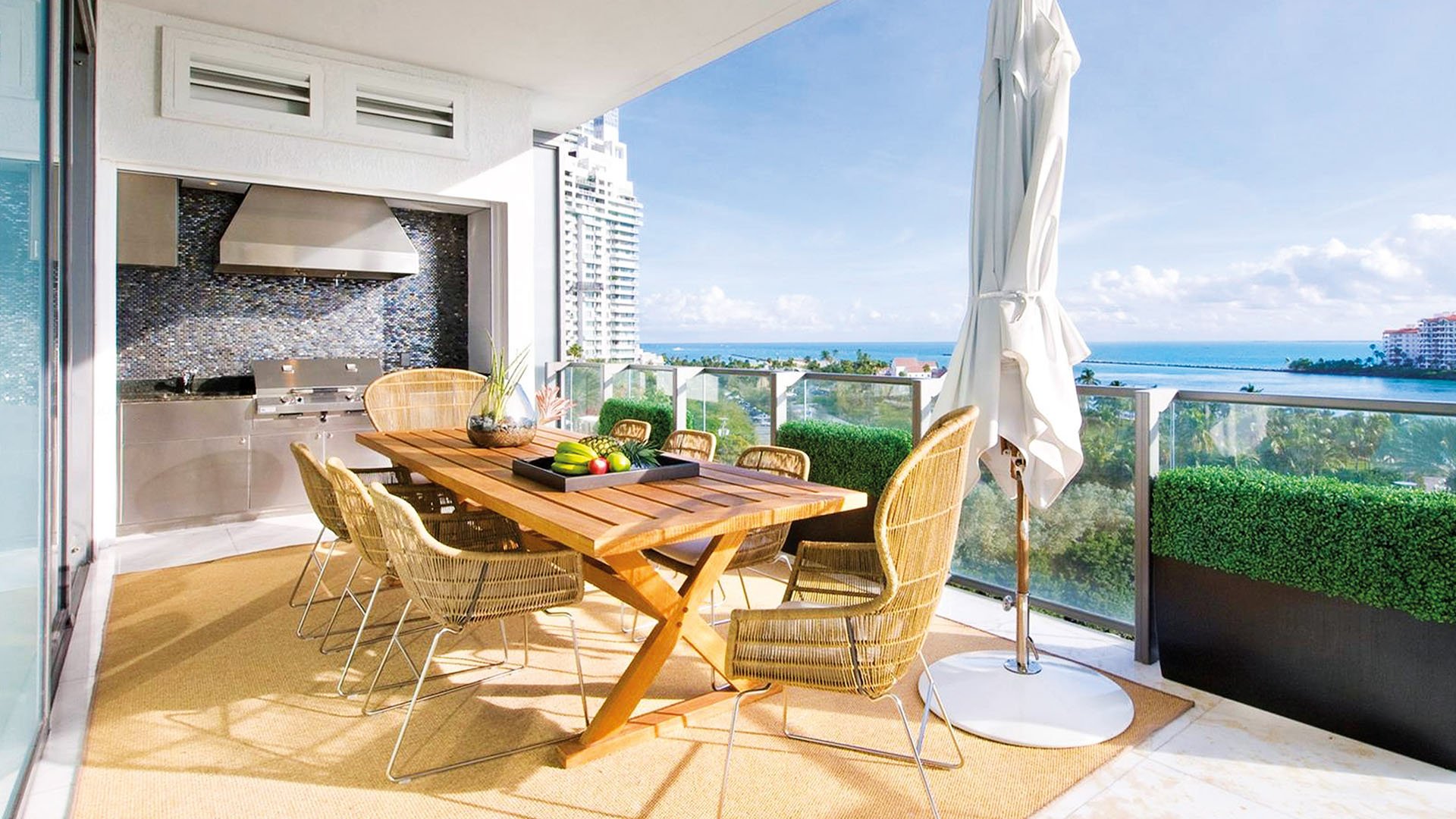 Covered terrace dining area with an outdoor kitchen and ocean views at Apogee in South Beach, showcasing luxury and ultra luxury condos with resort-style entertaining space.