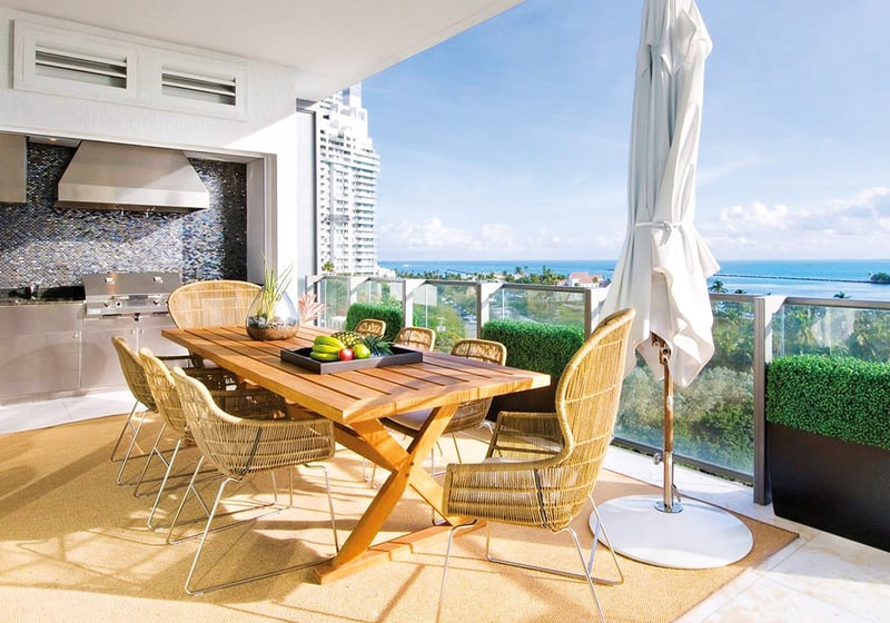 Covered terrace dining area with an outdoor kitchen and ocean views at Apogee in South Beach, showcasing luxury and ultra luxury condos with resort-style entertaining space.