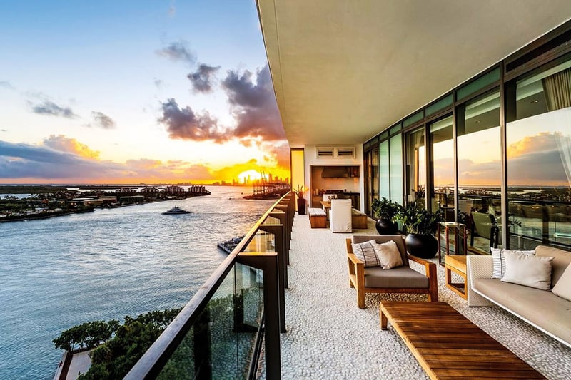 Sunset waterfront terrace with lounge seating and an outdoor kitchen at Apogee in South Beach, highlighting luxury and ultra luxury condos with expansive bayfront outdoor living.