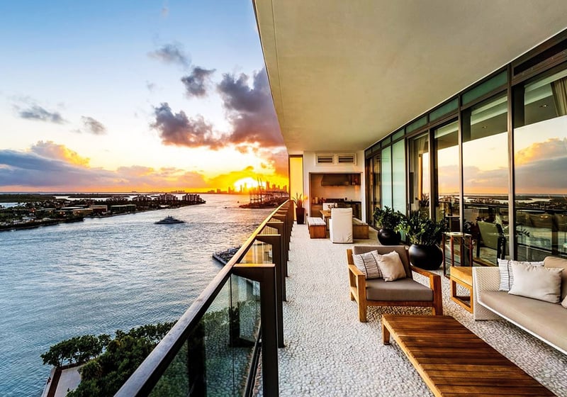 Sunset waterfront terrace with lounge seating and an outdoor kitchen at Apogee in South Beach, highlighting luxury and ultra luxury condos with expansive bayfront outdoor living.