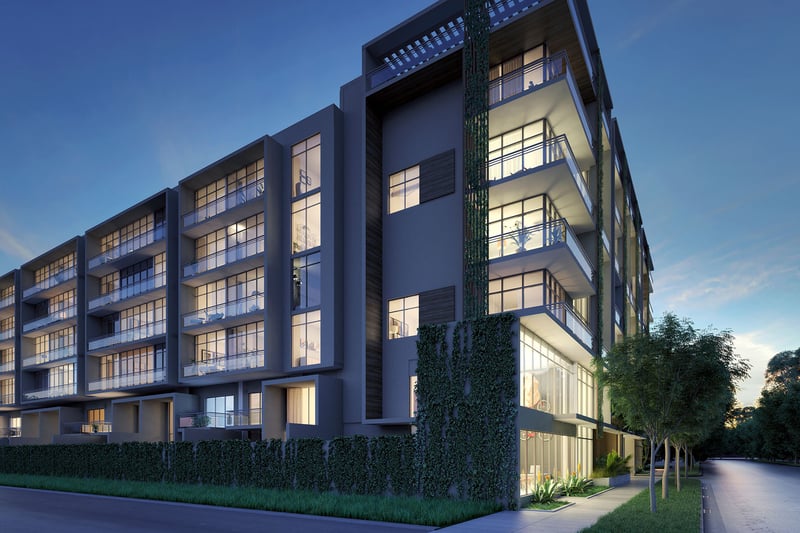 Dusk corner exterior of Arbor in Coconut Grove with stacked balconies, expansive glass and illuminated interiors, capturing luxury and ultra luxury condos in a low-rise modern building.