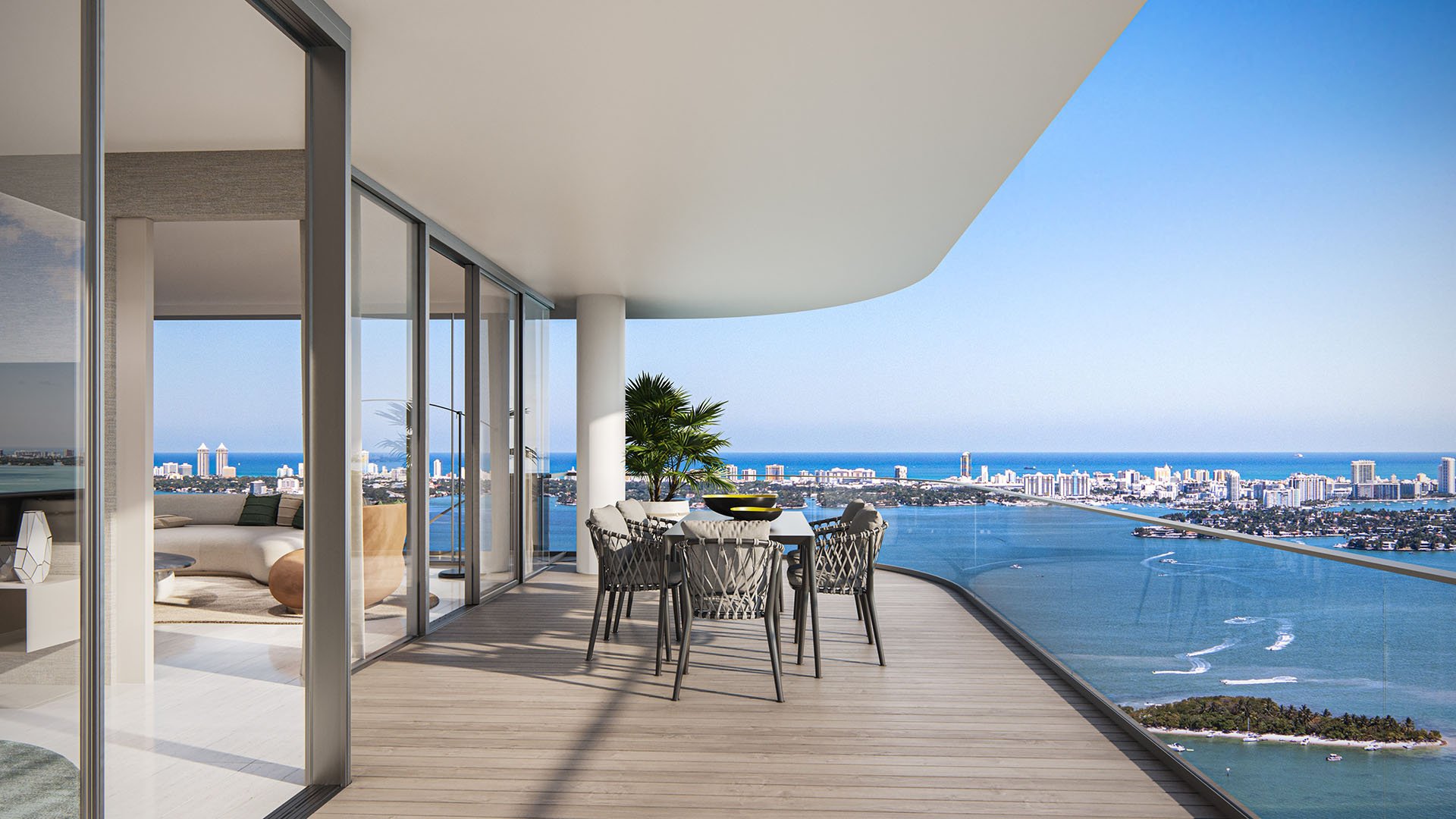 Aria Reserve Edgewater Miami wraparound condo balcony with outdoor dining and sweeping Biscayne Bay to Miami Beach ocean views, showcasing luxury and ultra luxury preconstruction condos in Edgewater.