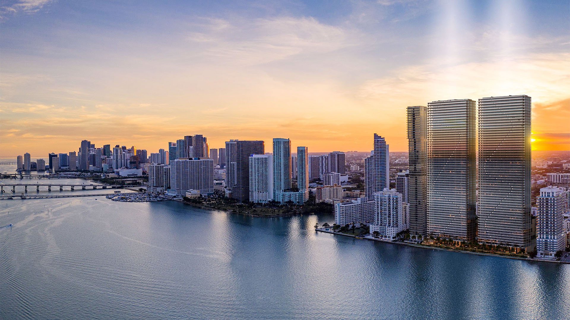 Aerial sunset view of Biscayne Bay and Downtown Miami with Aria Reserve twin towers on the Edgewater waterfront, showcasing luxury and ultra luxury preconstruction condos with panoramic skyline and bay views.