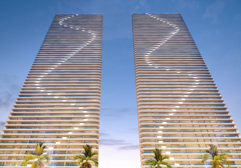 Twilight view of Aria Reserve twin towers in Edgewater, Miami, Florida with illuminated balcony lines against the evening sky, showcasing luxury and ultra luxury preconstruction condos on the Biscayne Bay waterfront.