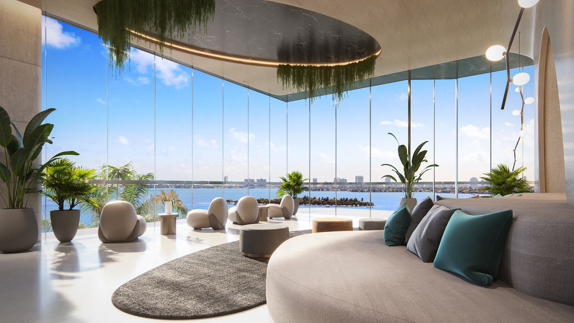 Aria Reserve in Edgewater, Miami, Florida waterfront lounge with curved sofa, ceiling greenery feature and wall-to-wall windows overlooking Biscayne Bay, featuring luxury and ultra luxury preconstruction condos with panoramic views.