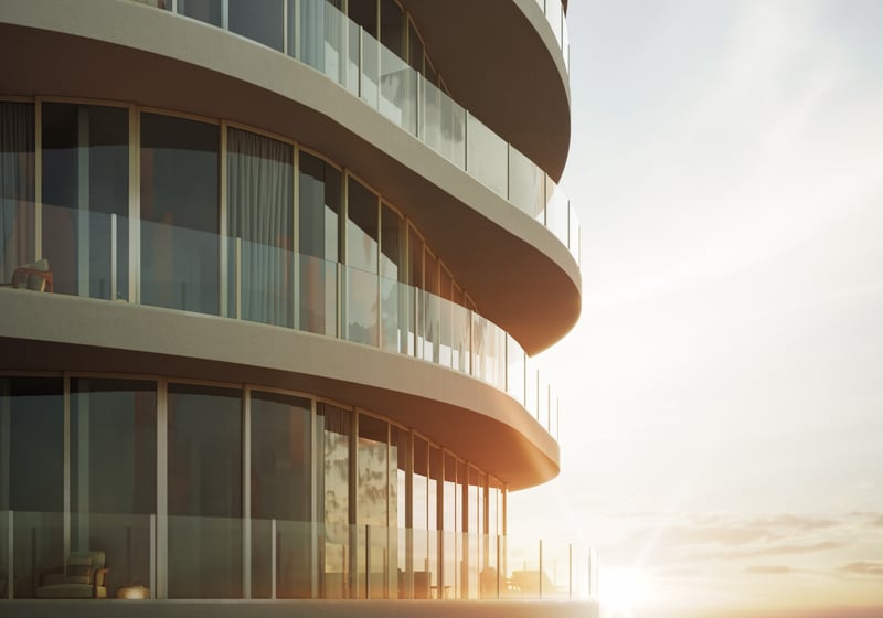 Armani Casa Pompano Beach. Curved, modern glass balconies of a building at sunset, with sunlight reflecting off the windows. Featuring architecture.