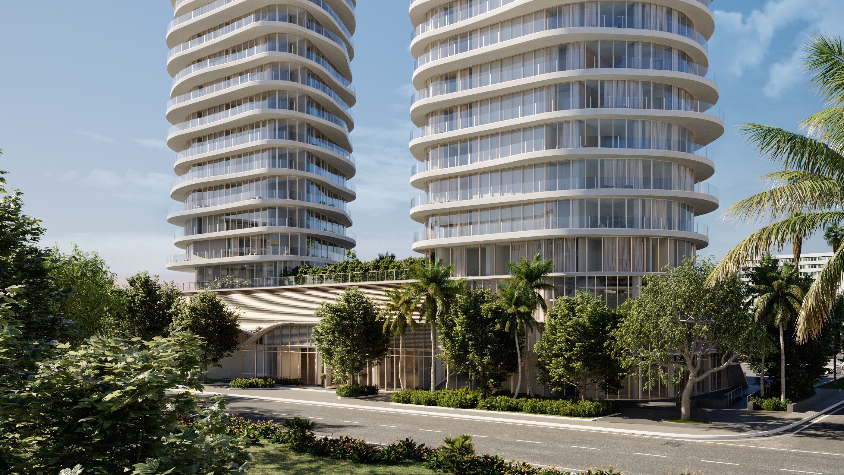 Armani Casa Pompano Beach. Two modern, curved high-rise buildings with glass facades surrounded by palm trees and lush greenery by a quiet street. Featuring architecture, towers, urban, and settings.