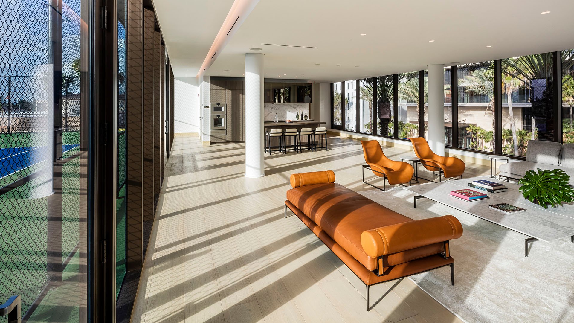 Amenities lounge at Arte Surfside, Surfside, Florida, showing luxury and ultra luxury condos with contemporary seating, a bar area, and views beside the court.