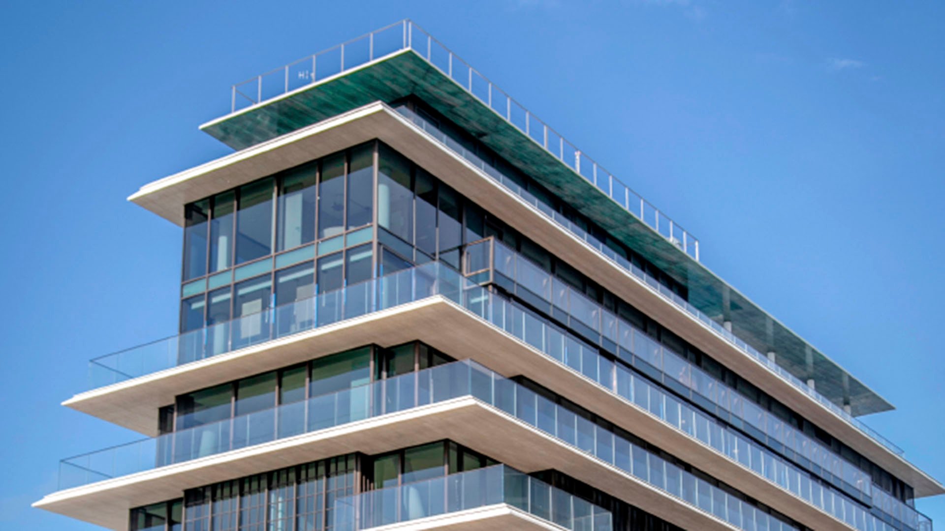 Corner residence exterior at Arte Surfside, Surfside, Florida, where luxury and ultra luxury condos feature wraparound balconies, full-height glass, and a rooftop terrace.
