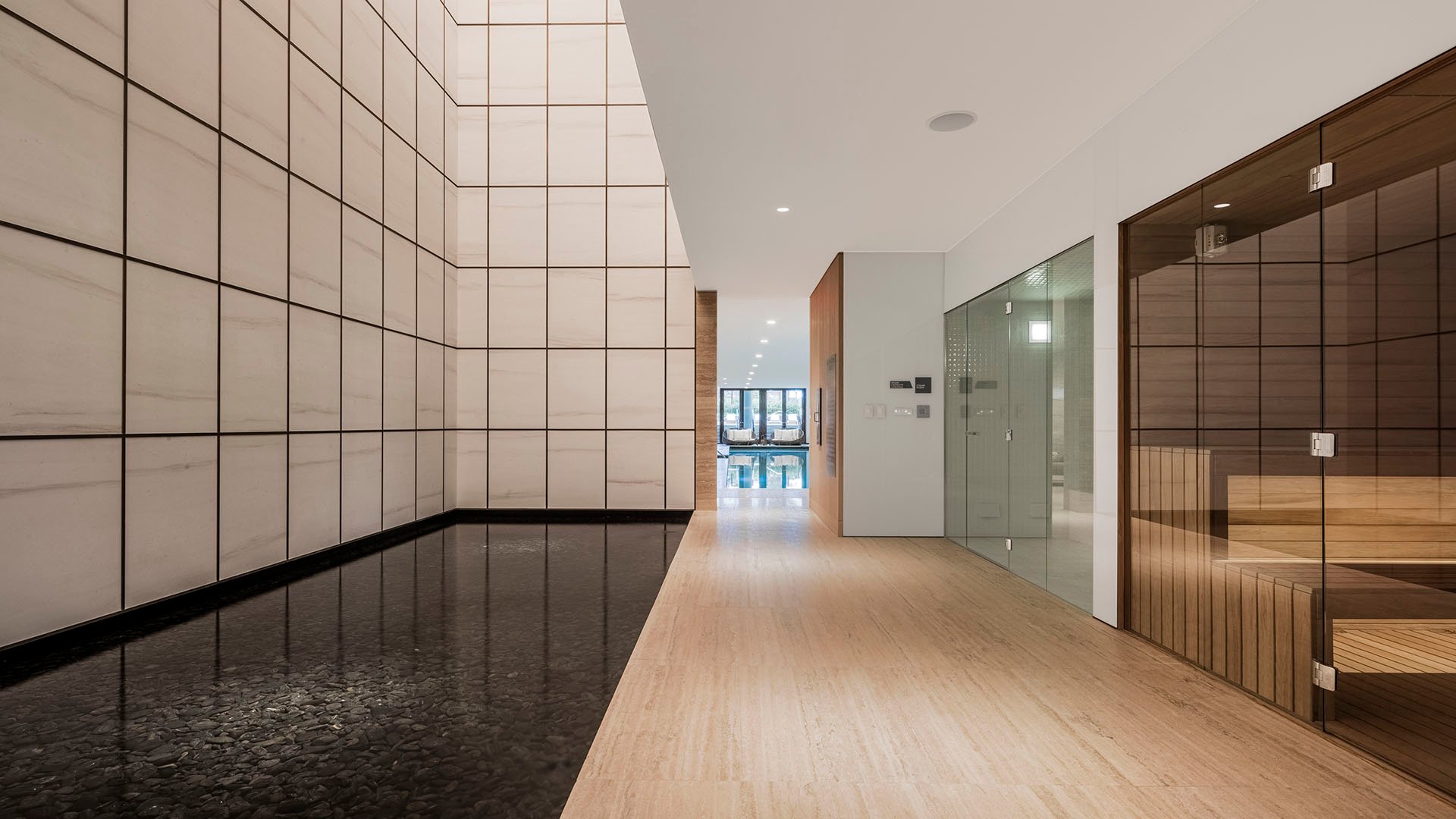 Spa corridor at Arte Surfside, Surfside, Florida, where luxury and ultra luxury condos include a sauna room, a dark water feature, and calm minimalist finishes.