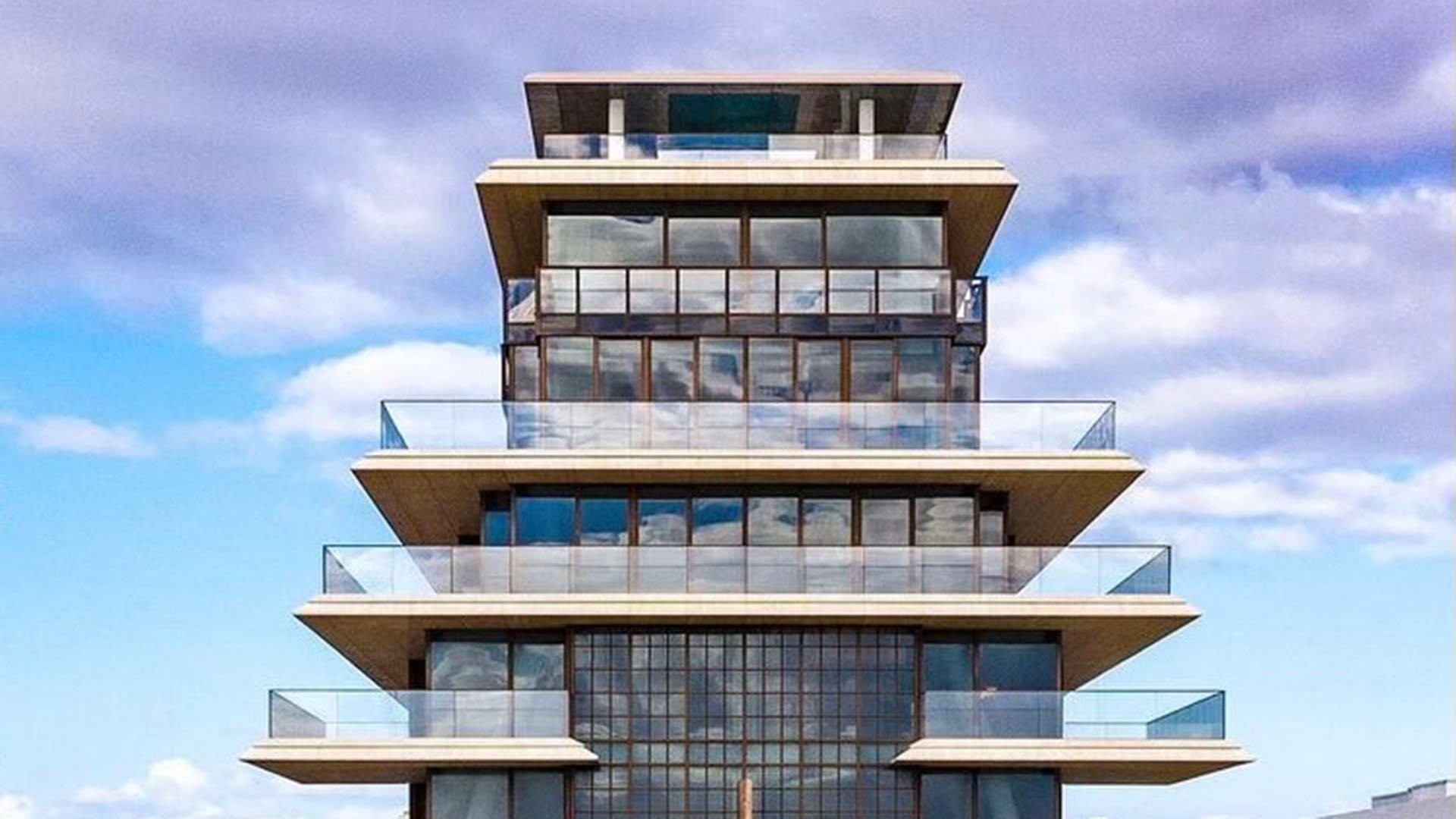 Symmetrical exterior at Arte Surfside, Surfside, Florida, highlighting luxury and ultra luxury condos with layered terraces and a sculptural stepped tower profile.