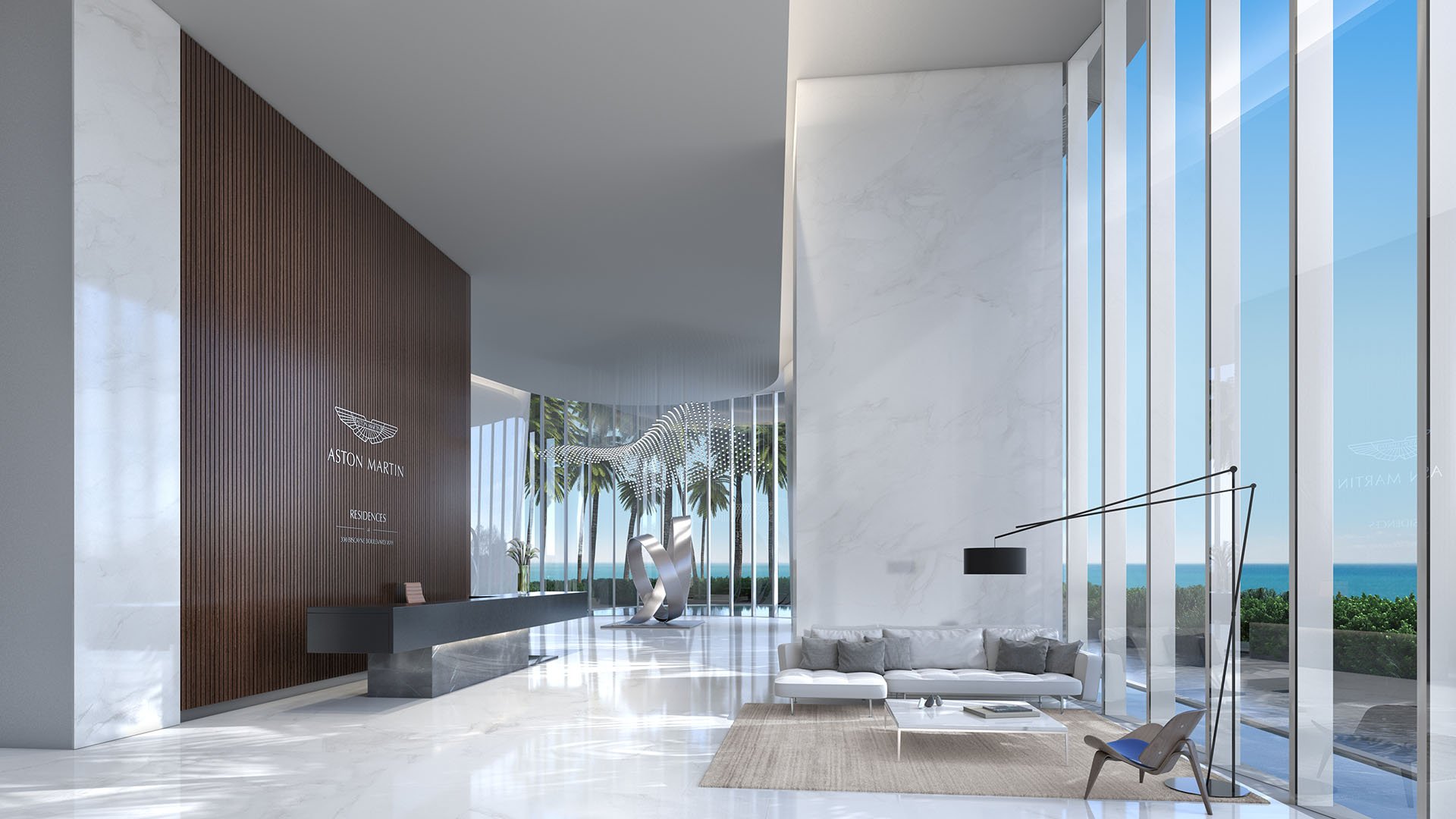 Aston Martin Residences in Downtown Miami luxury and ultra luxury condos arrival lobby with a sculptural art piece, reception desk, marble finishes, and a water view.