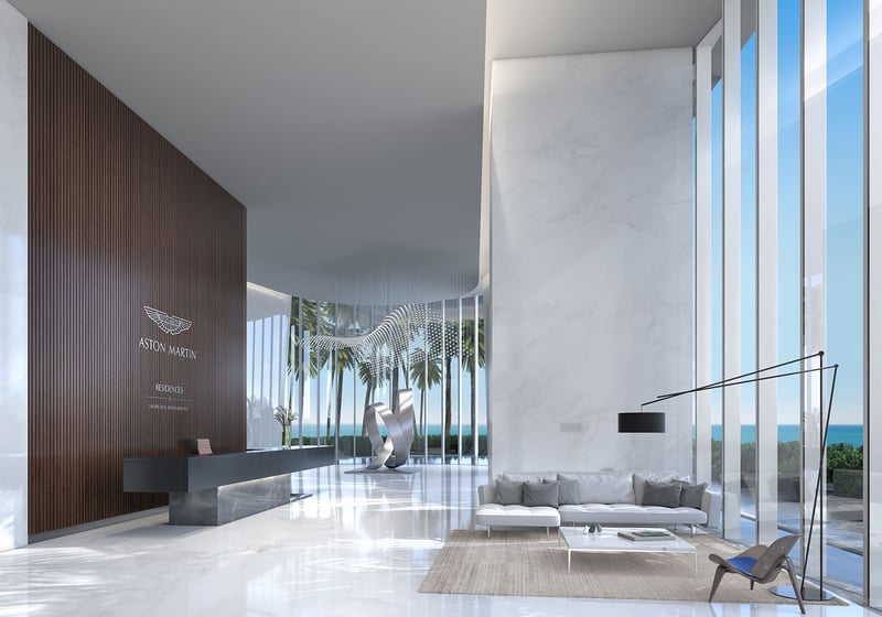 Aston Martin Residences in Downtown Miami luxury and ultra luxury condos arrival lobby with a sculptural art piece, reception desk, marble finishes, and a water view.