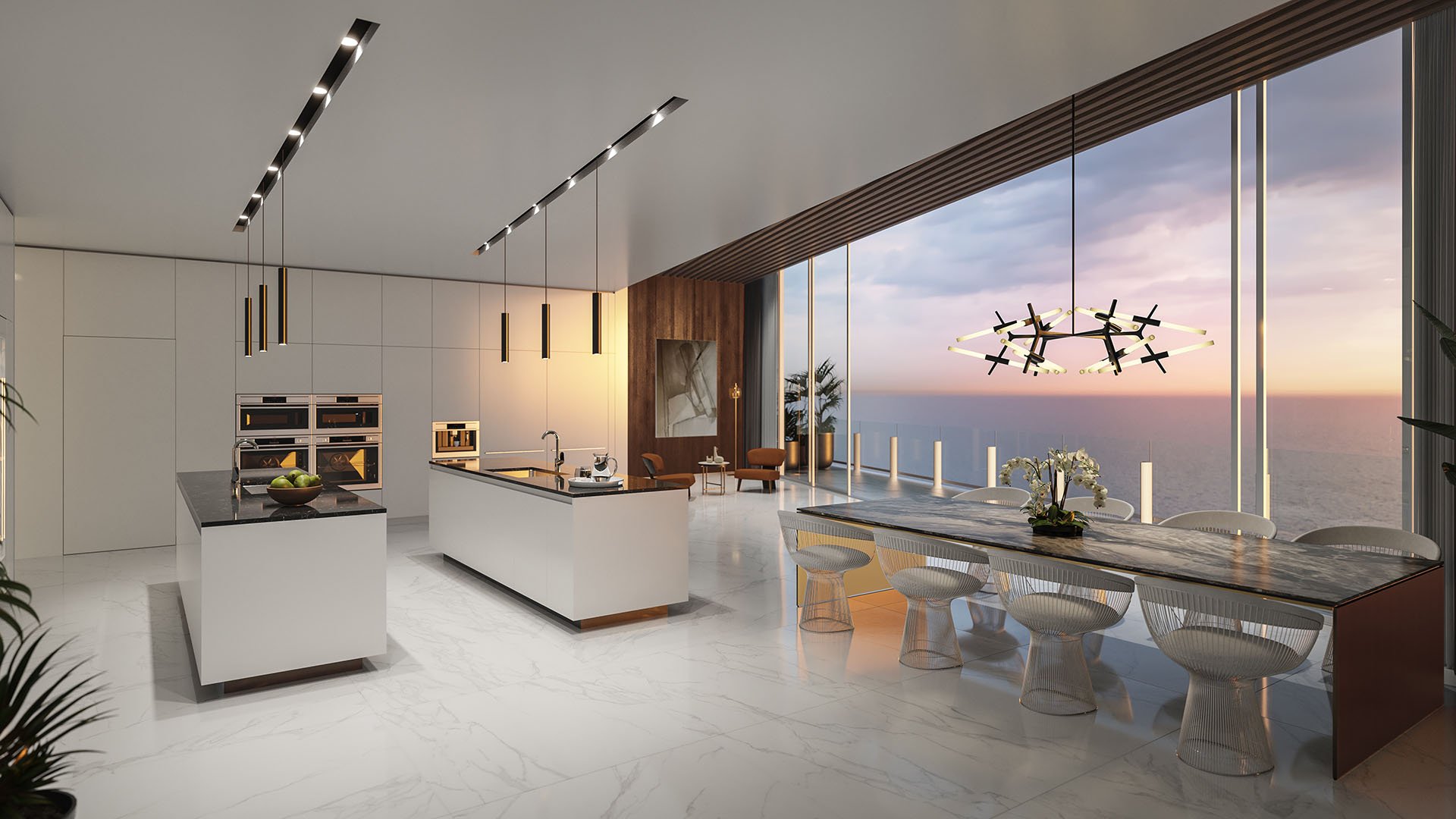 Aston Martin Residences in Downtown Miami luxury and ultra luxury condos chef kitchen with dual islands, dining table, and sunset water views through floor-to-ceiling glass.