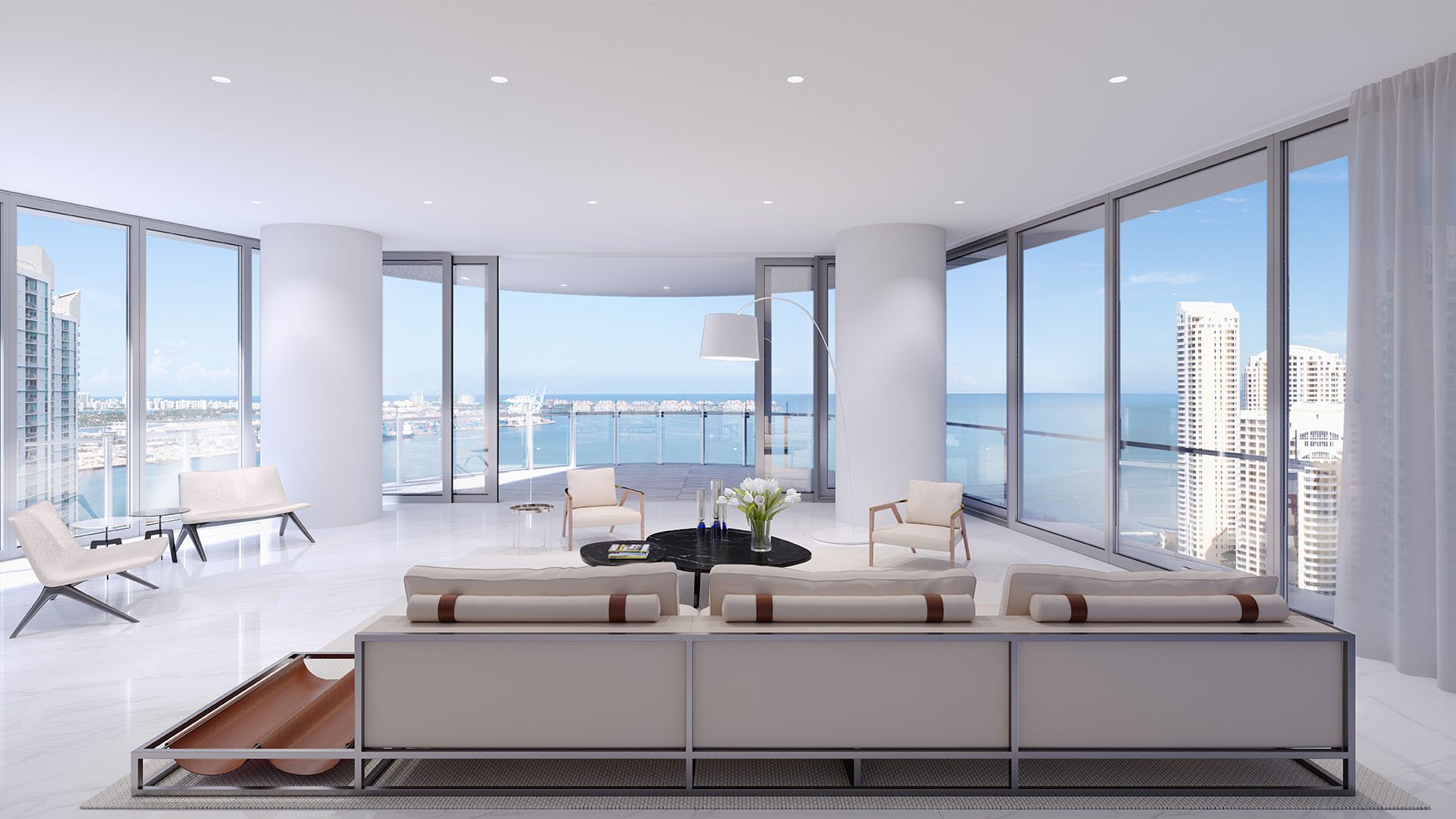 Aston Martin Residences in Downtown Miami luxury and ultra luxury condos expansive corner living room with wraparound glazing, a curved terrace, and wide water views.