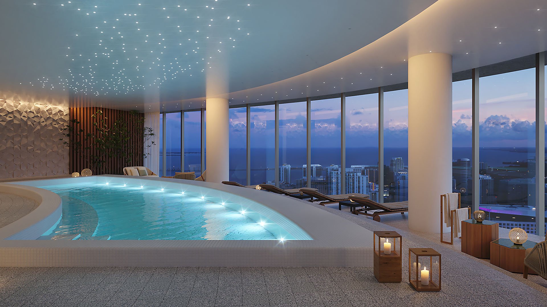 Aston Martin Residences in Downtown Miami luxury and ultra luxury condos indoor hydrotherapy pool with a curved ceiling, lounge chairs, candle lanterns, and skyline views.