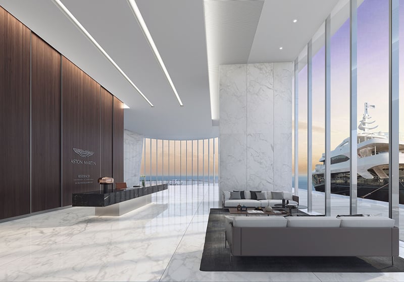 Aston Martin Residences in Downtown Miami luxury and ultra luxury condos marble lobby reception with a wood-paneled feature wall, lounge seating, and a sleek desk.