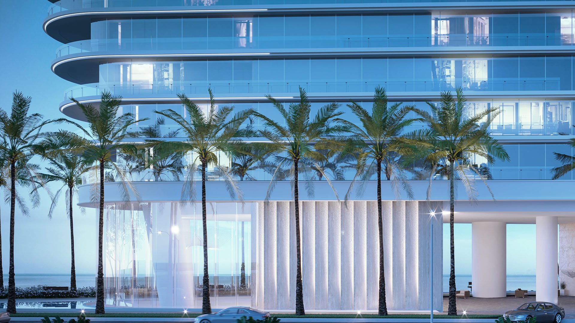 Aston Martin Residences in Downtown Miami luxury and ultra luxury condos palm-lined glass entrance podium exterior with rounded balconies and a sheltered dropoff.