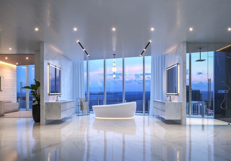 Aston Martin Residences in Downtown Miami luxury and ultra luxury condos spa bathroom with a freestanding tub, glass shower, dual vanities, and twilight skyline views.