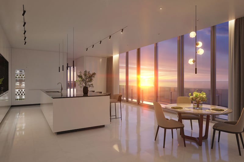 Aston Martin Residences in Downtown Miami luxury and ultra luxury condos sunset chef kitchen with an island, dining area, wine display, and glowing water views.