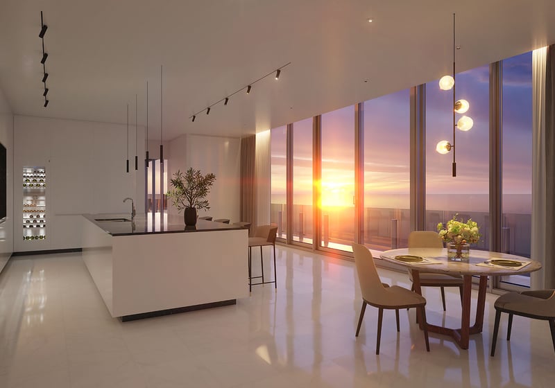 Aston Martin Residences in Downtown Miami luxury and ultra luxury condos sunset chef kitchen with an island, dining area, wine display, and glowing water views.