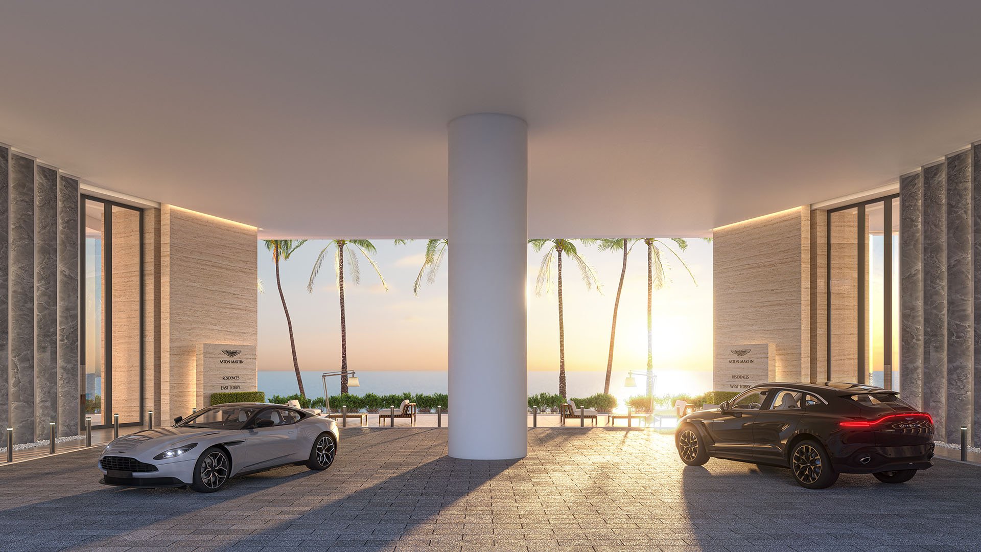 Aston Martin Residences in Downtown Miami luxury and ultra luxury condos symmetrical porte cochere dropoff with two luxury vehicles, palm trees, and sunset light by the water.