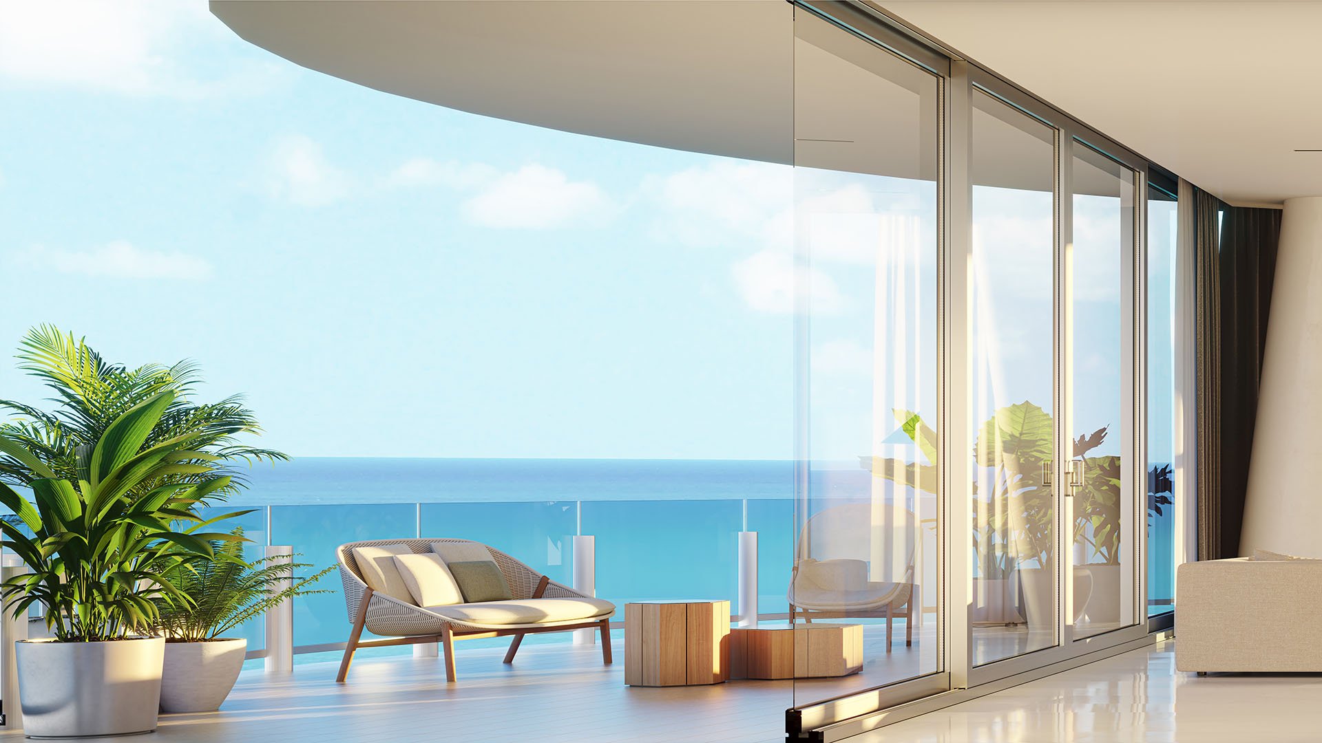 Aston Martin Residences in Downtown Miami luxury and ultra luxury condos waterfront terrace lounge with a curved overhang, chaise seating, and serene blue water views.