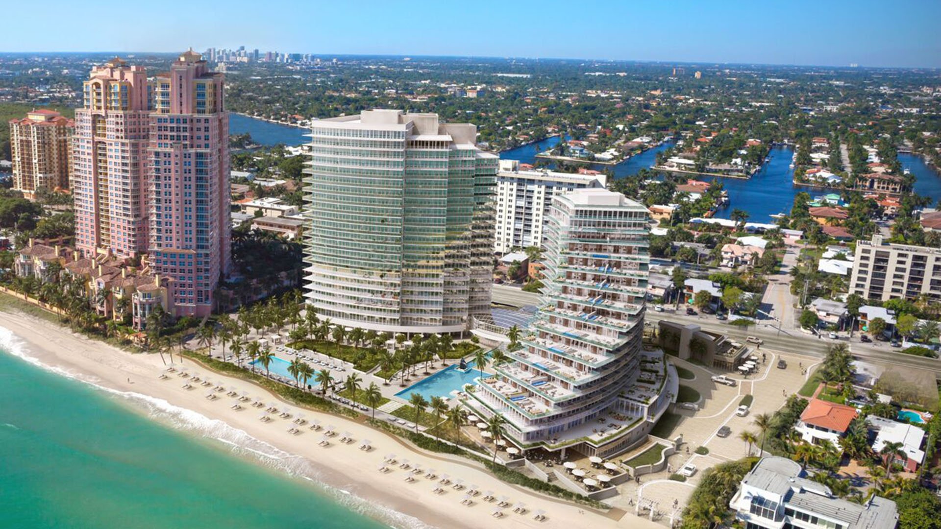 Auberge Beach Residences, Fort Lauderdale luxury and ultra luxury condos aerial waterfront view of curved beachfront towers, pools, the sandy beach, and surrounding coastal waterways.