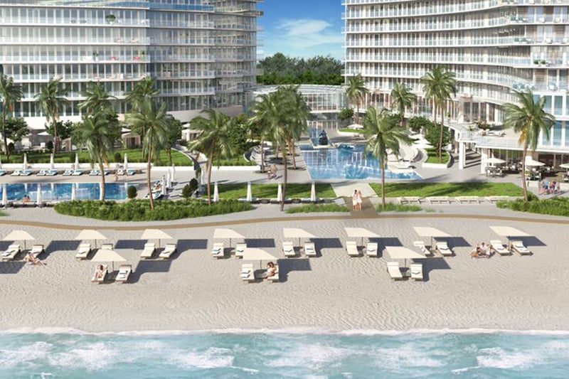 Auberge Beach Residences, Fort Lauderdale luxury and ultra luxury condos beachfront pool deck courtyard with palms, lounge chairs, twin towers, and direct views across the sand to the ocean.