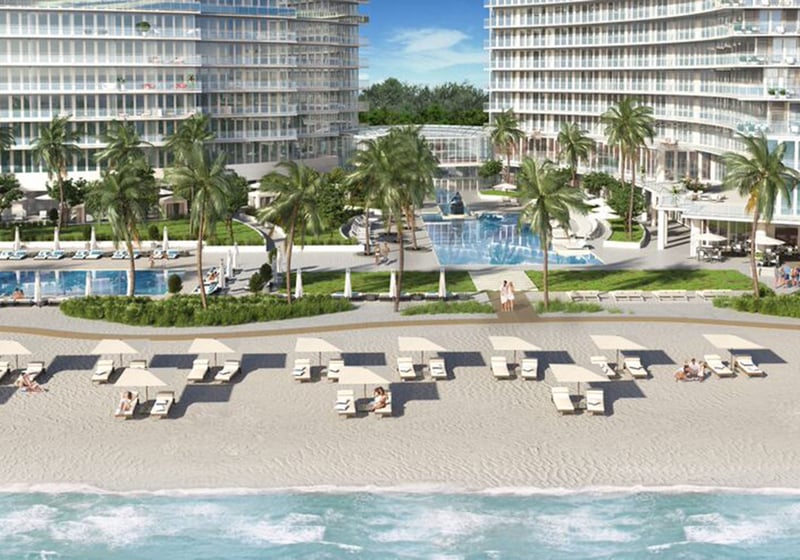 Auberge Beach Residences, Fort Lauderdale luxury and ultra luxury condos beachfront pool deck courtyard with palms, lounge chairs, twin towers, and direct views across the sand to the ocean.