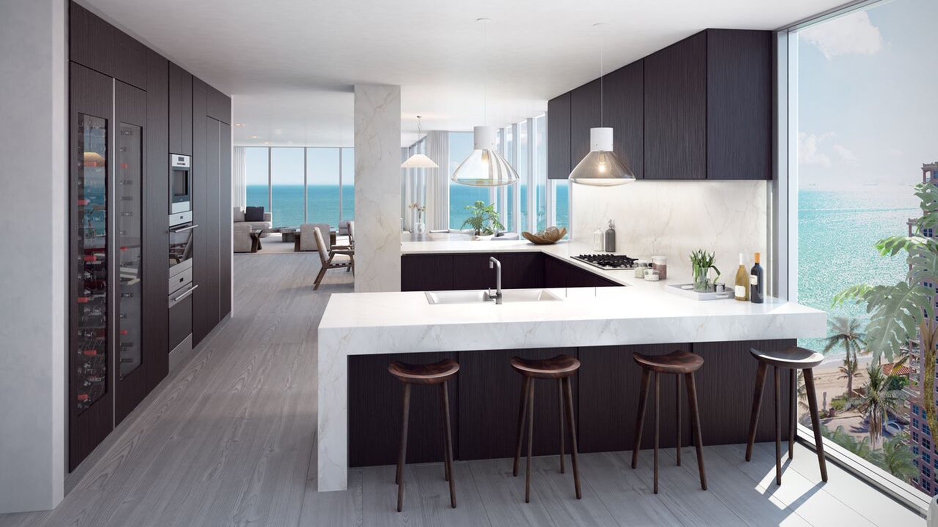 Auberge Beach Residences, Fort Lauderdale luxury and ultra luxury condos chef kitchen with a waterfall island, dark cabinetry, bar seating, and an open ocean view beyond the great room.