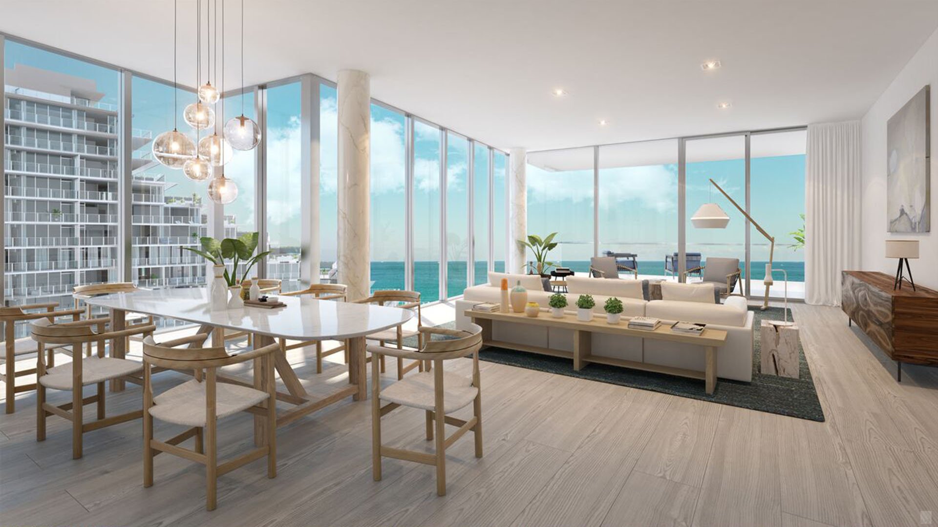 Auberge Beach Residences, Fort Lauderdale luxury and ultra luxury condos corner living and dining room with wraparound glass walls, neighboring tower views, and a bright open layout.