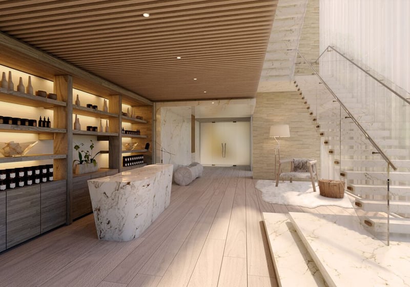 Auberge Beach Residences, Fort Lauderdale luxury and ultra luxury condos spa reception lounge with a marble desk, floating staircase, warm shelving, and serene natural finishes.