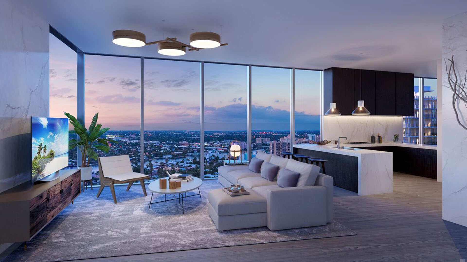 Auberge Beach Residences, Fort Lauderdale luxury and ultra luxury condos twilight family room with an open kitchen, floor-to-ceiling glass, and a panoramic skyline view.