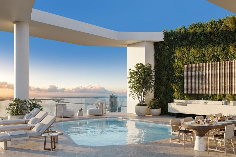 Baccarat Residences in Brickell, Miami, luxury and ultra luxury condos featuring a penthouse pool terrace, outdoor dining, a green wall, sun loungers, and panoramic bay views.