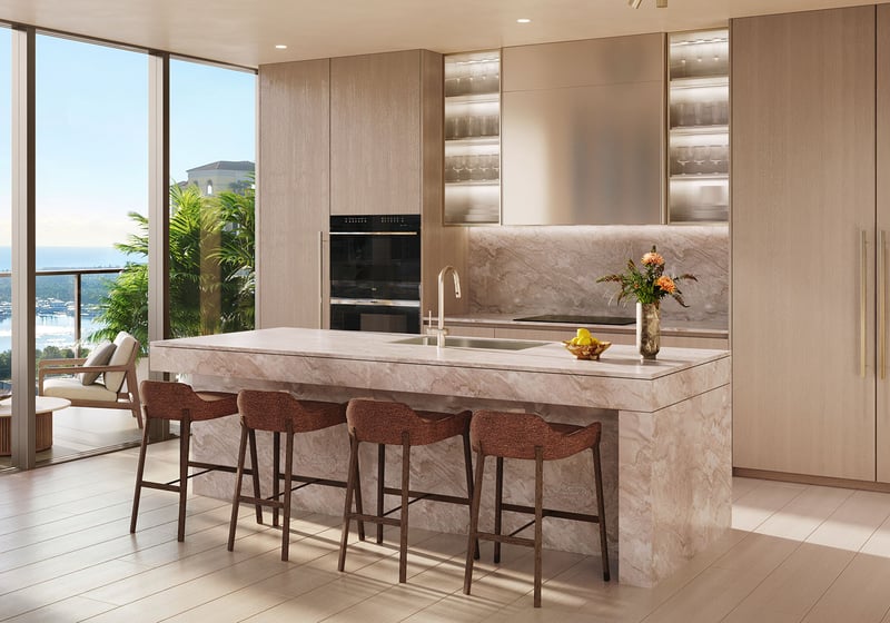 Chef kitchen with a large stone island, bar seating, and full-height windows framing the water at Banyan Tree Residences in West Palm Beach, showing luxury and ultra luxury condos with bright open-plan interiors.